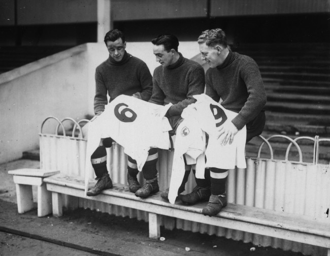3rd January 1939:  Three Tottenham Hotspur FC soccer players looking at their new numbered football shirts for the third round FA cup tie against Watford at White Hart Lane, London. Left to right Duncan, A Hall, and W Hall (Capt).  (Photo by Stephens/Topical Press Agency/Getty Images)