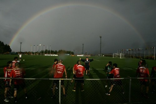 A rainbow forms in the sodden skies behind Chile coach Nelson Acosta and his players